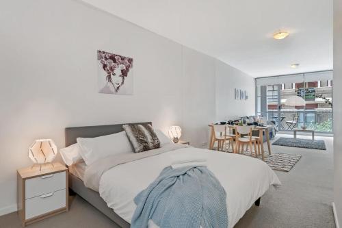 a bedroom with a bed and a dining room at A Comfy & Modern Studio Near Darling Harbour in Sydney