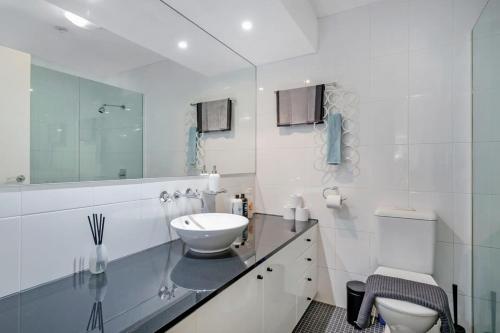 a white bathroom with a sink and a toilet at A Comfy & Modern Studio Near Darling Harbour in Sydney