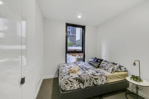 - une chambre avec un lit et une fenêtre dans l'établissement A Comfy 2BR Apt 5-Min Walk To Melbourne Central, à Melbourne