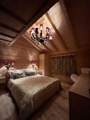 a bedroom with a large bed and a chandelier at Chalet Riedhuus in Davos Wolfgang