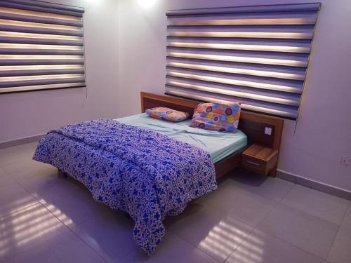 ein kleines Bett in einem Zimmer mit Fenster in der Unterkunft An Entire Rare Stylish 5-Bedroom Bungalow in Akure