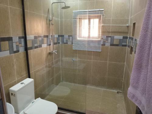 a bathroom with a shower with a toilet and a glass shower at An Entire Rare Stylish 5-Bedroom Bungalow in Akure