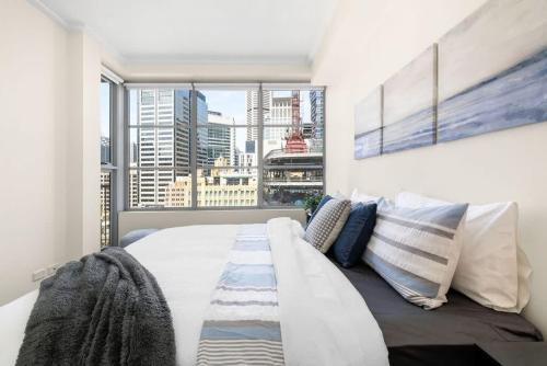 um quarto com uma cama grande e uma janela grande em A Stylish Apt City Views Next To Darling Harbour em Sydney