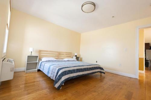 聯城的住宿－Luxurious 3-Bed Apt - mins to NYC，一间卧室配有一张床,铺有木地板