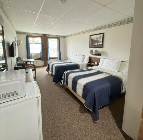 una camera d'albergo con due letti e una televisione di Lake Ontario Motel & Inn a Newfane
