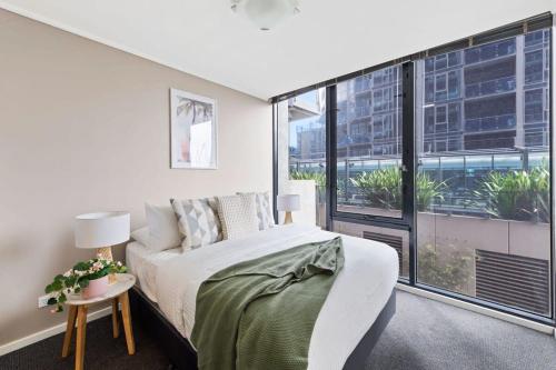 a bedroom with a bed and a large window at A Large 2BR Apt Near Crown Sleeps 8 FREE Parking in Melbourne