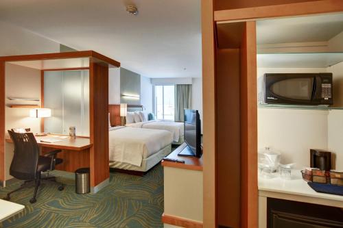 a hotel room with a bed and a desk and a television at SpringHill Suites by Marriott Dallas Plano/Frisco in Plano