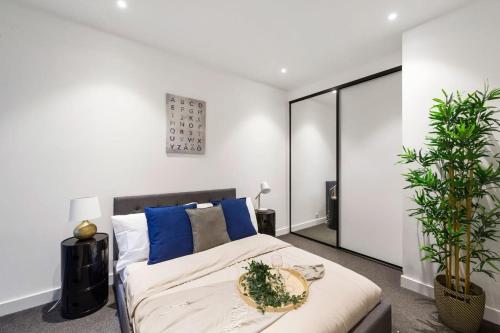 um quarto com uma cama grande e almofadas azuis em A Stylish 2BR Apt Near Melbourne Central em Melbourne
