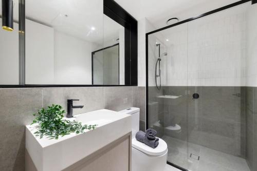 uma casa de banho com um WC, um lavatório e um chuveiro em A Stylish 2BR Apt Near Melbourne Central em Melbourne