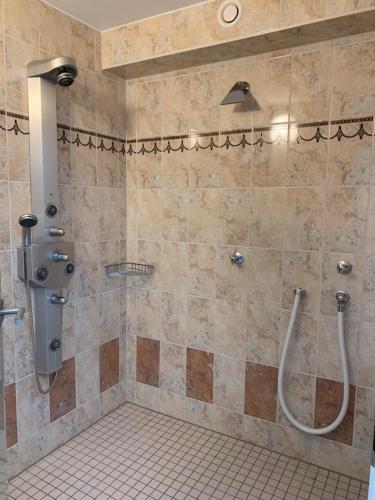 y baño con ducha y suelo de baldosa. en Haus am Pfingstborn, en Ober-Mörlen