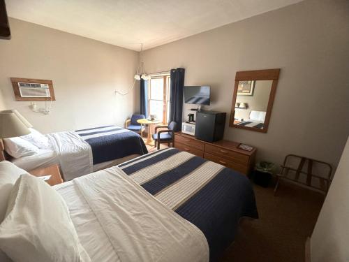 a hotel room with two beds and a mirror at Lake Ontario Motel & Inn in Newfane