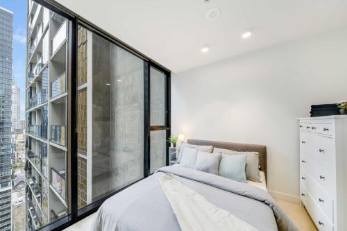 1 dormitorio con cama y ventana grande en A Comfy 2BR Apt Near to Melbourne Central, en Melbourne
