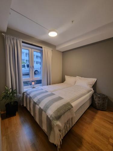 1 dormitorio con 1 cama grande y ventana en Central Apartment Ålesund, en Ålesund