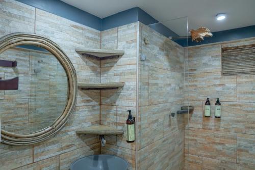 a bathroom with a round mirror and a sink at La Playita Isla Fuerte in Isla Fuerte