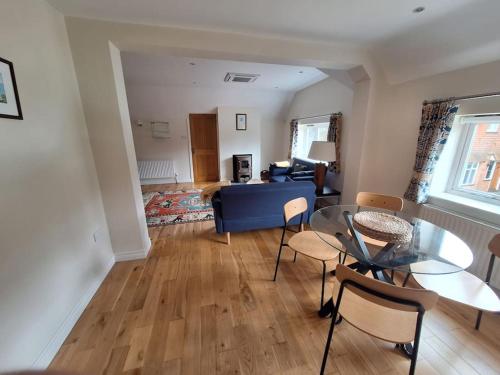 a living room with a blue couch and a glass table at Rural Retreat near Dorking in Dorking