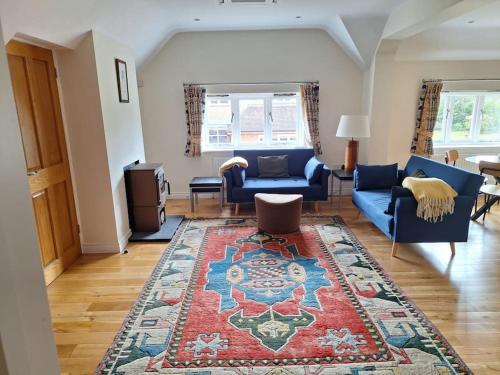 a living room with blue couches and a rug at Rural Retreat near Dorking in Dorking