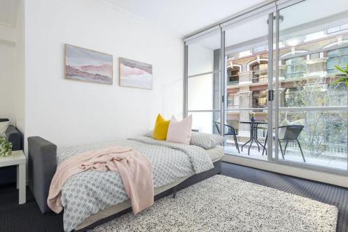 a bedroom with a bed and a large window at A Comfy Studio for 6 Next to Darling Harbour in Sydney