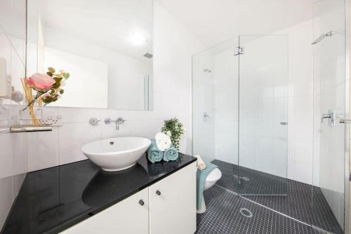 a white bathroom with a sink and a toilet at A Comfy Studio for 6 Next to Darling Harbour in Sydney