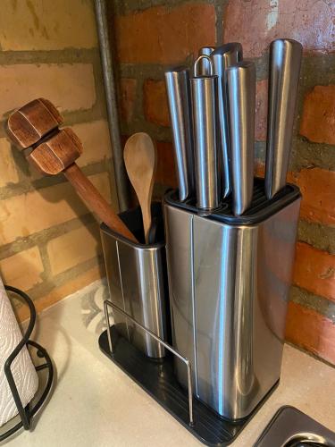 a container of utensils on a counter with a wooden spoon at Container convertido en acogedor apartamento in Cajicá