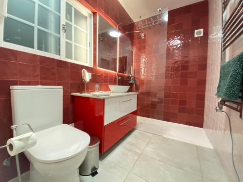 y baño con aseo, lavabo y ducha. en Casa Rosa en Lagos