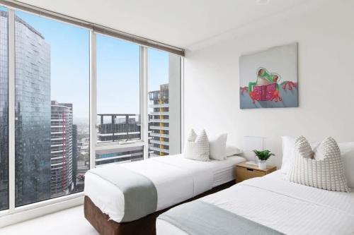 - 2 lits dans une chambre avec une grande fenêtre dans l'établissement Comfy & Stylish 2BR Apt Next to Crown City Views, à Melbourne