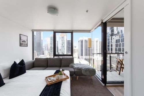 墨尔本A 3BR Apt Next to Southern Cross FREE Parking的带沙发和大窗户的客厅