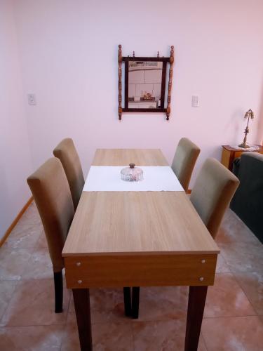 a wooden table with chairs and a mirror on the wall at Escalera al éxito Villa Ramallo in Estación Ramallo