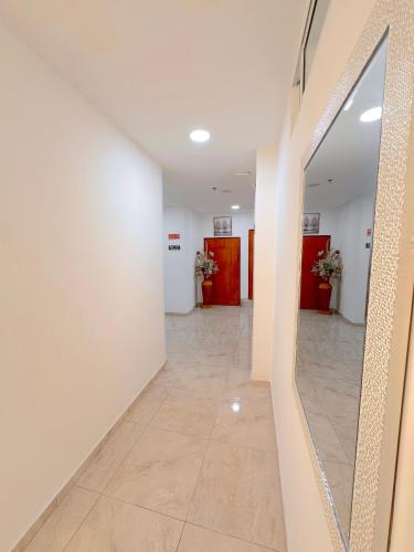 a hallway with white walls and a mirror at Hotel Grand Caribe in San Andrés