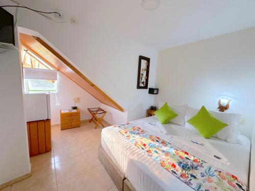 a bedroom with a white bed with green pillows at Hotel Grand Caribe in San Andrés