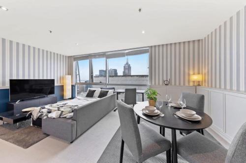 a living room with a couch and a table at Comfy CBD Apt in QV with City Views FREE Parking in Melbourne
