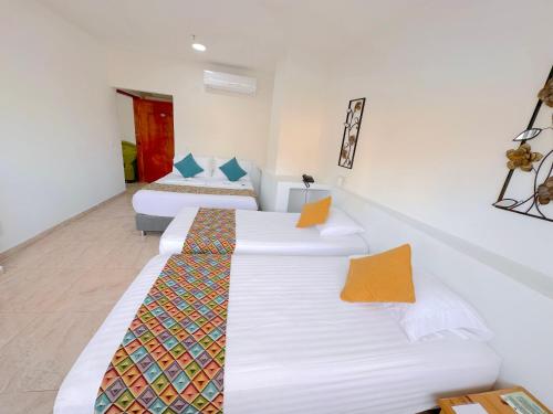a hotel room with two beds and a couch at Hotel Grand Caribe in San Andrés