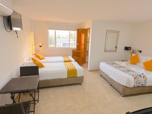 a hotel room with two beds and a television at Hotel Grand Caribe in San Andrés