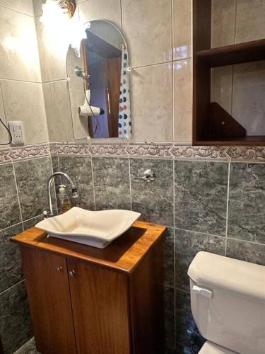 a bathroom with a sink and a toilet and a mirror at Casa Comoda Centrica con Garage in Puyo