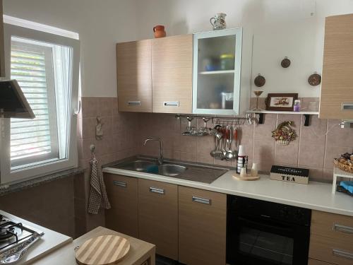 a kitchen with wooden cabinets and a sink and a stove at Villa Melania in Rossano