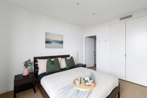 Un dormitorio con una cama y una bandeja. en Cozy 2BR Apt Near Melbourne Central w City Views en Melbourne