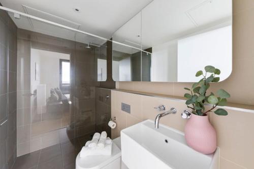 baño con lavabo y jarrón con planta en Cozy 2BR Apt Near Melbourne Central w City Views en Melbourne