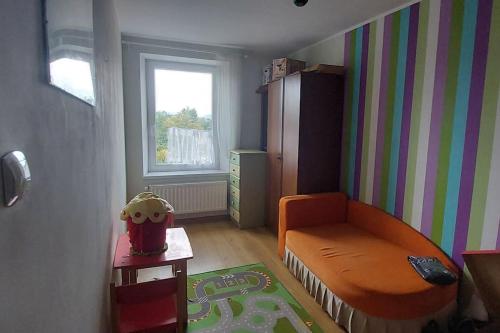 a small room with a bed and a chair at HarmonyHub in Wałbrzych