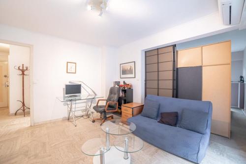 een woonkamer met een blauwe bank en een tafel bij Beauvallon furnished flat in Cannes