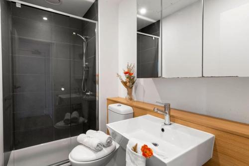 La salle de bains est pourvue d'un lavabo, d'une douche et de toilettes. dans l'établissement A Chic 2BR Apt City Views Near Southern Cross, à Melbourne