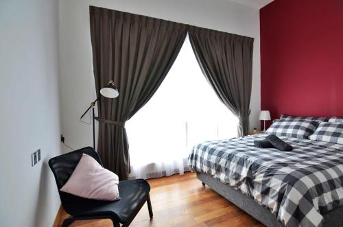um quarto com uma cama, uma cadeira e uma janela em Comfy 2BR TriTower Suite next to JB CIQ, JBCC & Capri em Johor Bahru