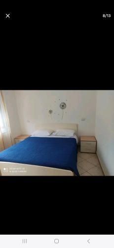 een slaapkamer met een bed met een blauw dekbed bij Da Leo in Marina di Montenero