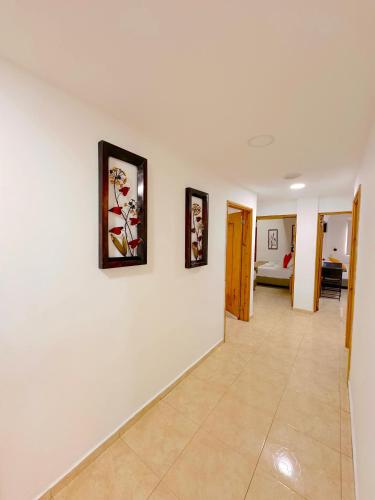 a hallway with two pictures on a white wall at Hotel Grand Caribe in San Andrés