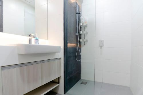une salle de bain blanche avec un lavabo et une douche dans l'établissement TOTORO Theme Suite in Suasana JB, à Johor Bahru