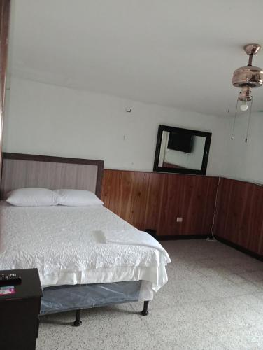 1 dormitorio con cama y espejo en la pared en Mundo Hostal, en Guatemala