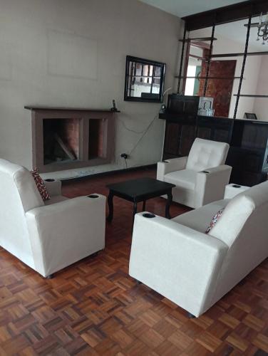 sala de estar con sofás blancos y chimenea en Mundo Hostal, en Guatemala