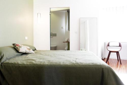 a bedroom with a bed and a chair in a room at Casa dos Aromas - Nature Tourism in Alvados