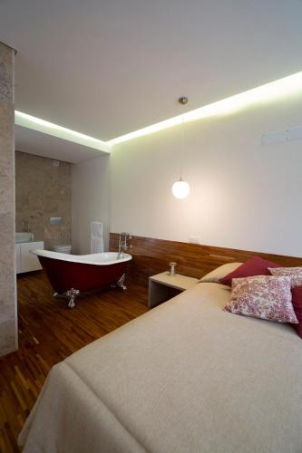 a bedroom with two beds and a bathtub and a bath tub at Casa dos Aromas - Nature Tourism in Alvados