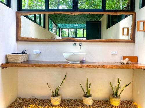 a bathroom with a sink and a mirror at Villas Zamna - Jungle Villas in Cozumel