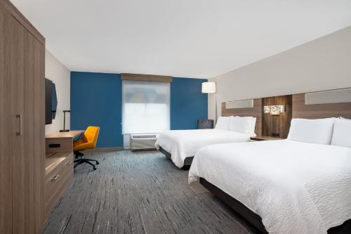 a hotel room with two beds and a television at Holiday Inn Express Hotel & Suites Terre Haute by IHG in Terre Haute