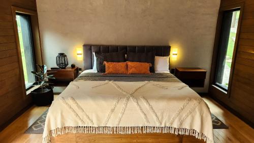 マサミトラにあるCHALET NORDICAのベッドルーム1室(大型ベッド1台、オレンジ色の枕付)